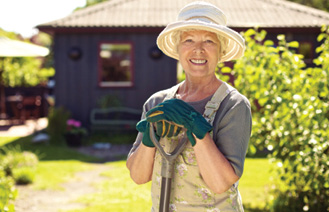 cheerful elderly woman with gardening tool