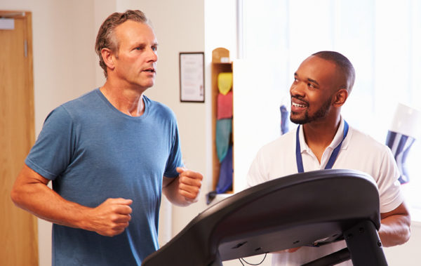 patient on treadmill in rehab with doctor
