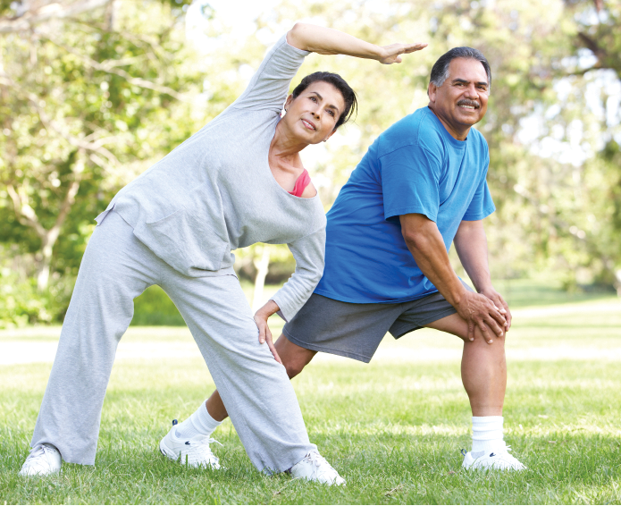 couple doing yoga stretches in the park in the afternoon