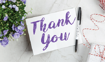 Photo of Thank You Note sitting on table with pen and flowers