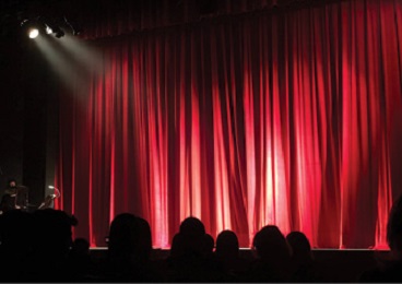 view from backrow of Musical Theater red draped curtains with spotlights