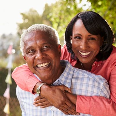Older black couple embracing and smiling for photo