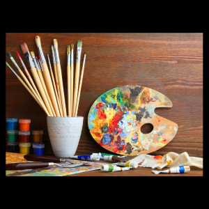 paint, paint brushes, and paid board sitting against a wooden backdrop