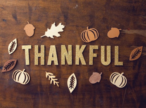 thankful in wood letters with small fall decorative decals: leaves, pumpkins, and acorns.