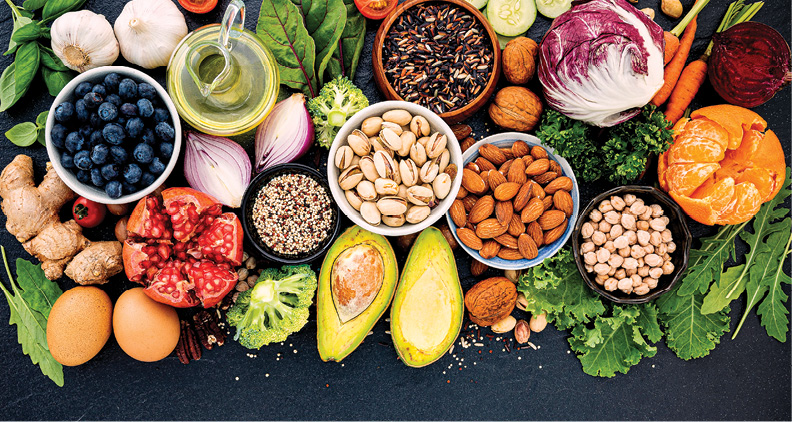 large display of fruits, vegetables, nuts, eggs, leafy greens on table