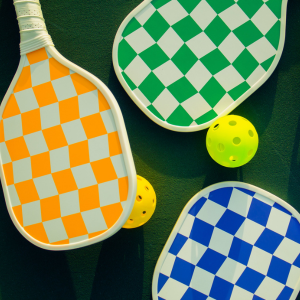 Pickleball paddles and whiffle balls displayed on court